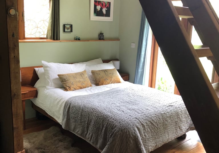 holiday rental interior view under the wooden staircase through to the double bed