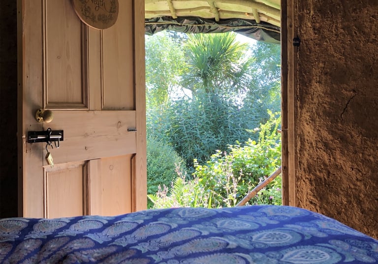 view out from a bedroom to a lush green garden