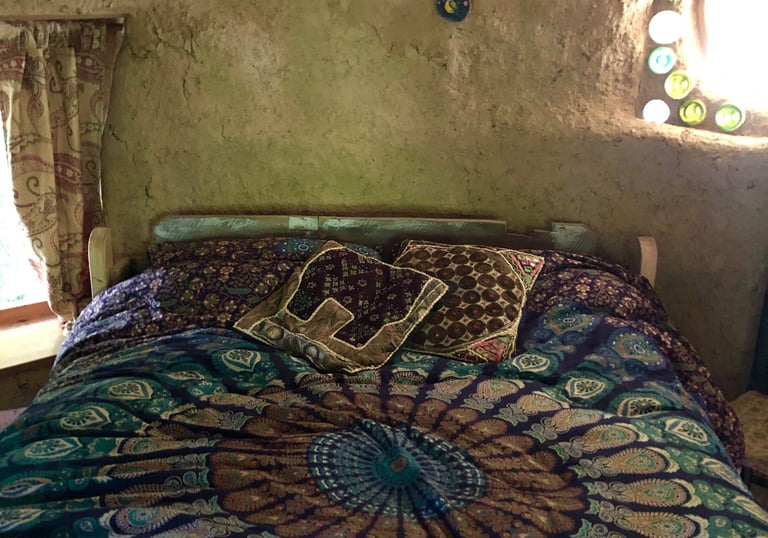 interior view of round house holiday let showing a double bed with a blue mandala bed cover