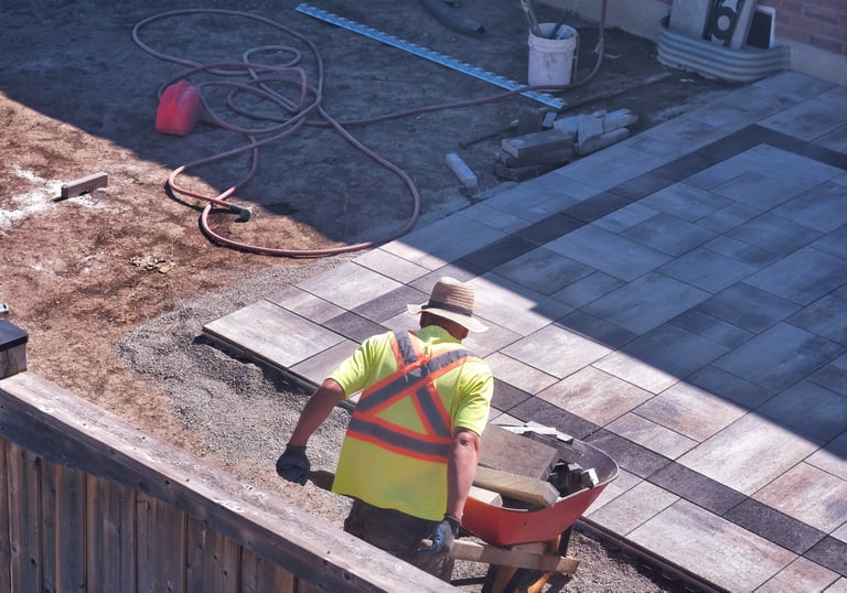 Sarasota patio installation in progress with contractor laying multicolor concrete pavers and gravel