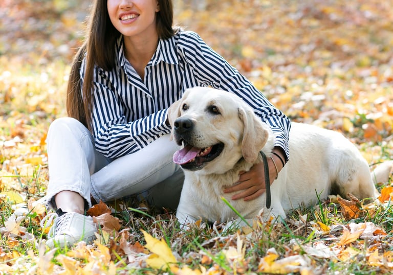 a woman sitting on the ground with her dog