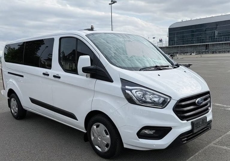 a white van parked in an airport parking lot