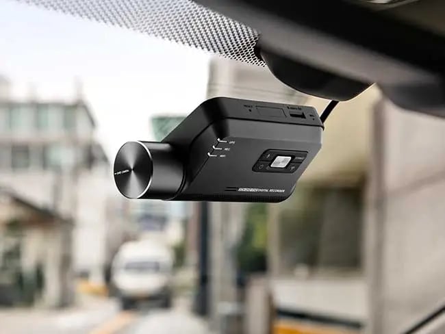 Thinkware dash cam mounted on car windscreen for smart driving video recording and safety.