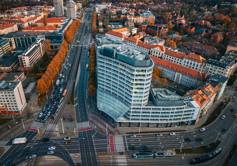 Aerial view of modern architecture and city traffic in Wroclaw, Poland during autumn sunset.
