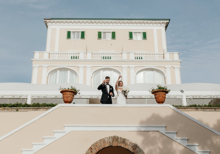 a bride and groom standing on a staircase way