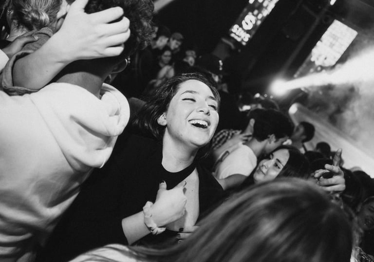 Besijuokianti moteris šoka minioje per muzikinį koncertą.