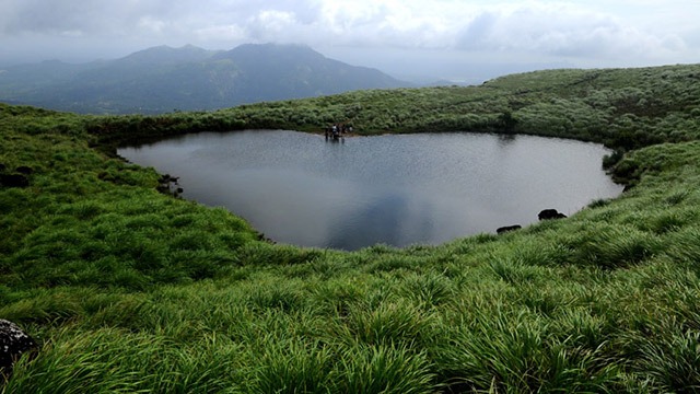 A panoramic view of Karapuzha Resorts, featuring cozy cottages and well-maintained gardens with the 