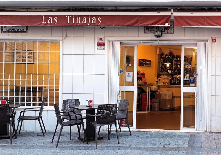 Vista exterior del Bar Las Tinajas Huelva, con mesas al aire libre, invitando a disfrutar de la comida.