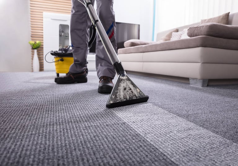 a man cleaning a carpet with a vacuum