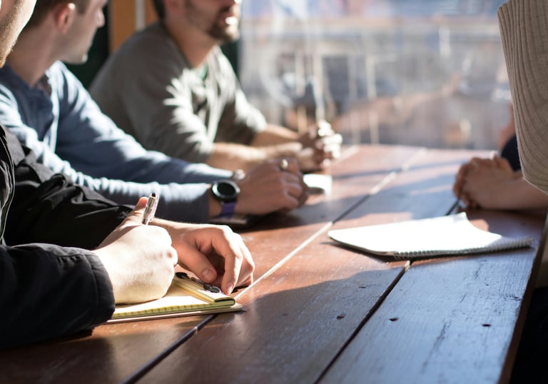 Group meeting around wooden table discussing client-centric approach