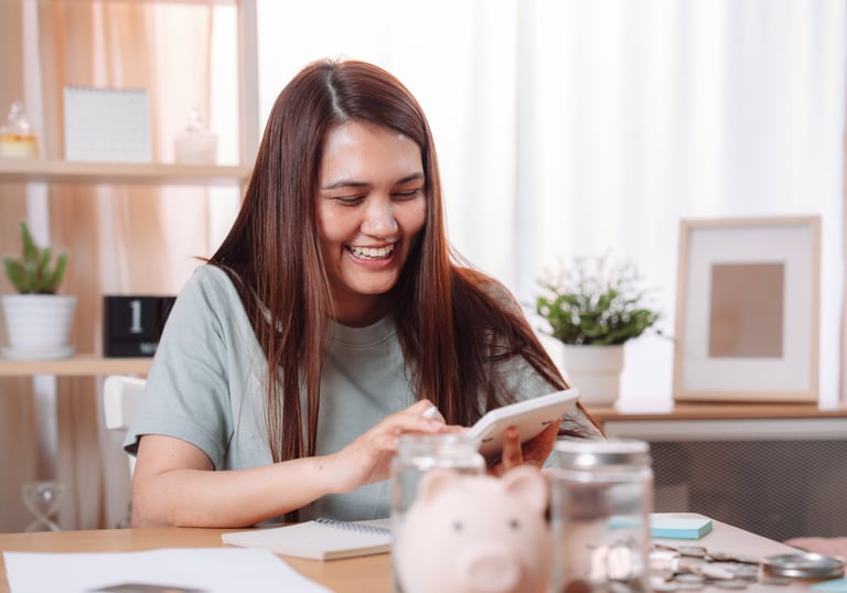a woman sitting at a table with a piggy