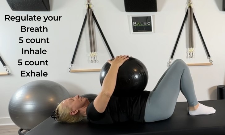 a woman showing individuals how to work with a ball therapeutically