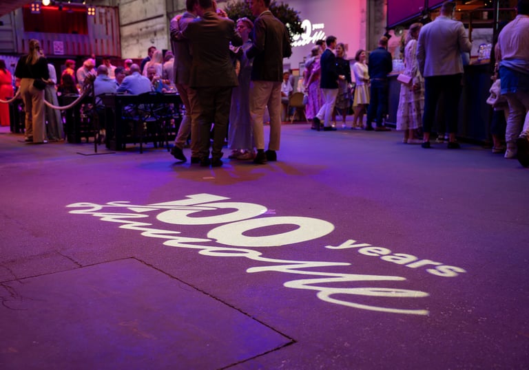 Eventlocation mit stehenden Personen und dem Schriftzug 100 years Lamotte