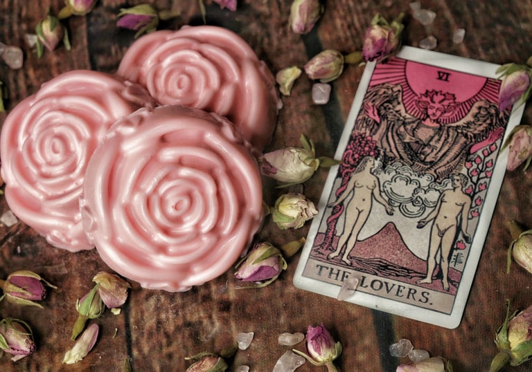 3 pink rose shaped soaps next to two tarot cards with a pink hue