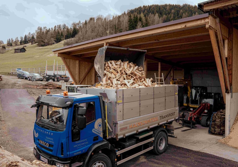 ein radlader füllt einen lkw mit brennholz, scheitholz, kaminholz,