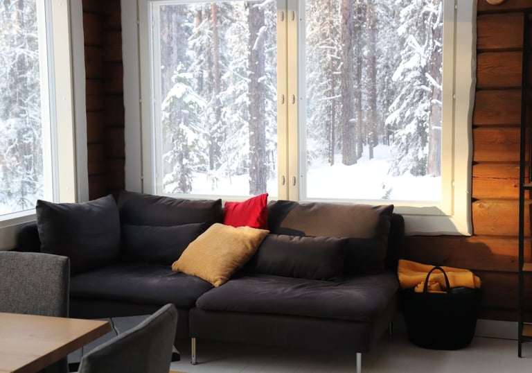 comfortable couch in a log cabin living room, big panoramic windows with views of snowy forrests
