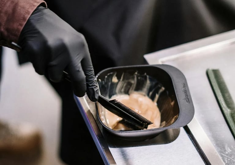 A hairstylist in gloves is fixing a woman hair.