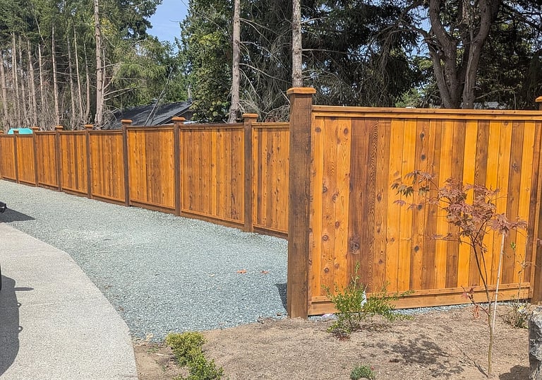 New spray-stained fencing, with tamped and leveled gravel service area