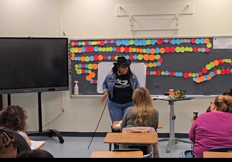A teacher wearing a cowboy hat leads an interactive classroom presentation for adult learners.