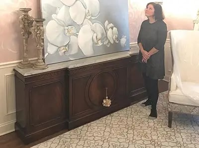 marcine standing next to orchid painting in pennington nj