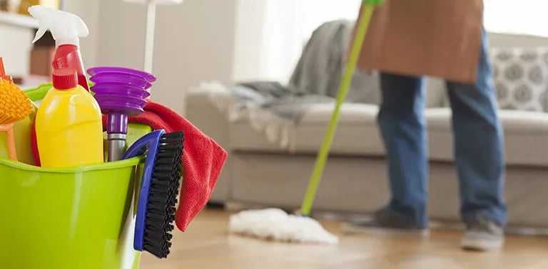 a bucket of cleaning supplies in a living room