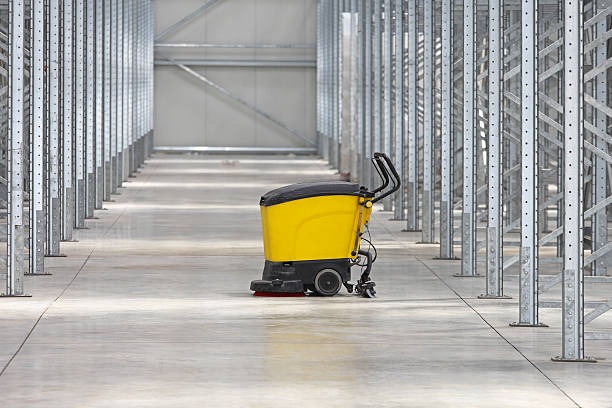 a yellow machine is cleaning a floor in a warehouse