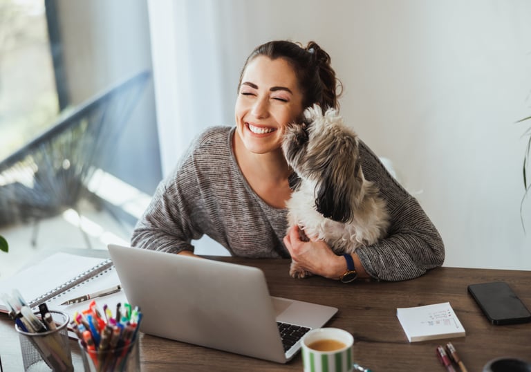 a woman sitting at a desk with a dog