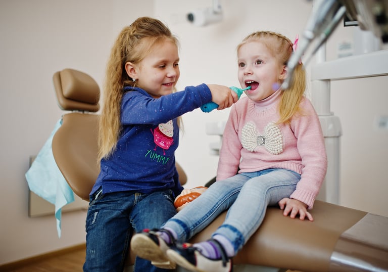 niñas sentadas en sillón dental
