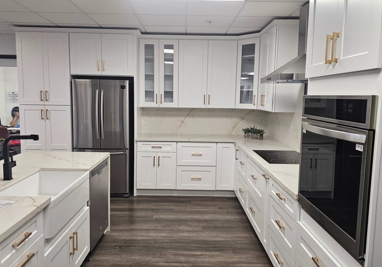 Modern kitchen with white cabinets, stainless steel appliances, and a large island.