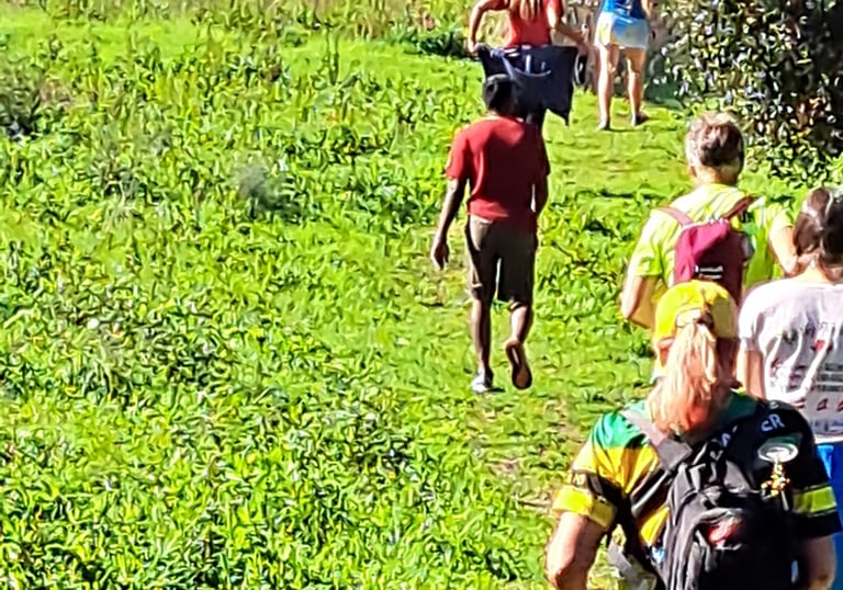 people climbing a grassy trail