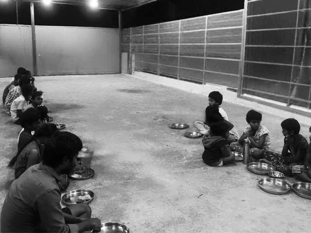 a group of people sitting on the ground eating food food green Way Association