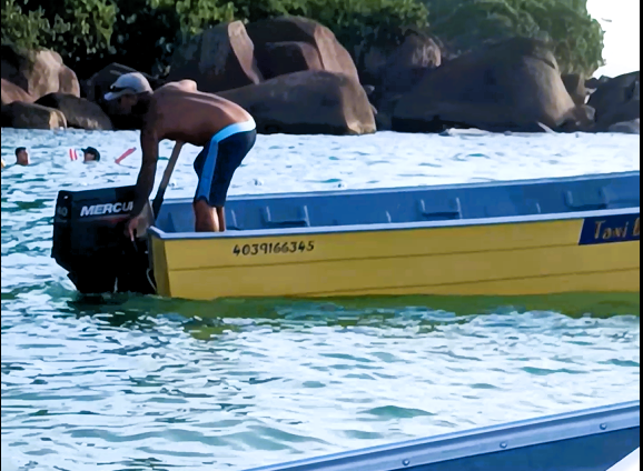Homem pilotando barco no Prumirim