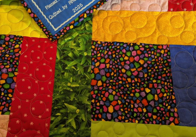 a colorful quilt with part of an embroidered label visible
