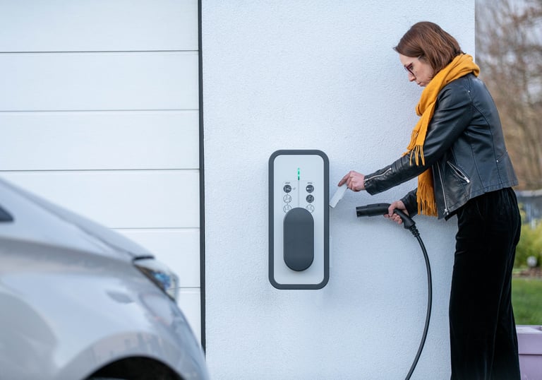 Madame recharge son véhicule électrique avec une borne Witty de Hager