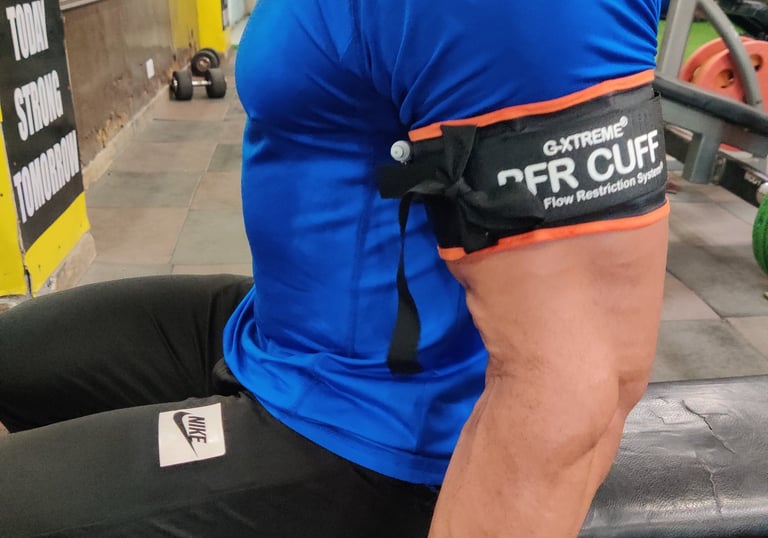 atient performing a leg press exercise with BFR cuffs applied, by Dr. Piyush Jain at the Galene