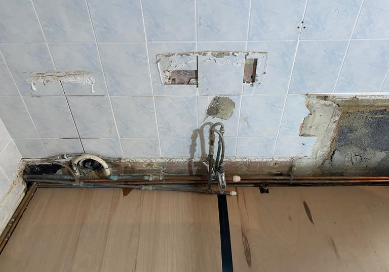 Pipework exposed to allow it to be re-laid for a new basin and toilet