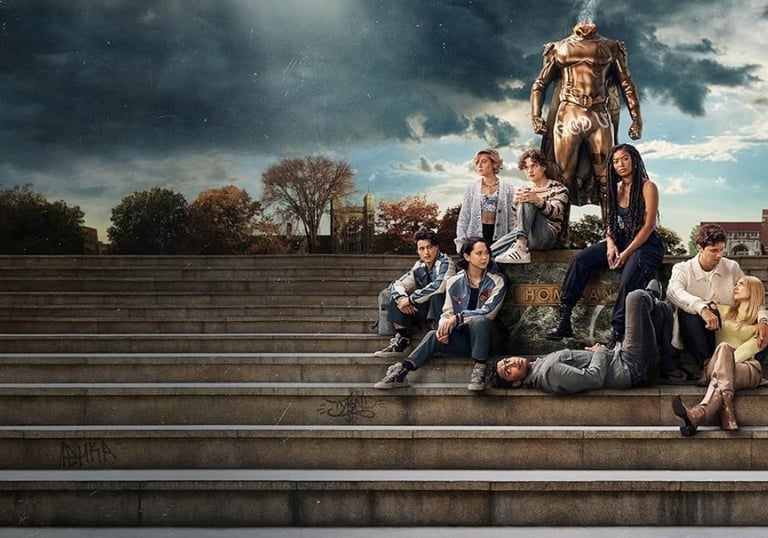 a group of people sitting on steps with a statue of a man