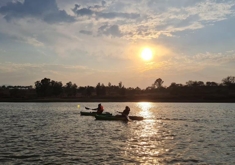 Madre e hija remando sobre aguas tranquilas en la presa de la Vega rodeadas de naturaleza