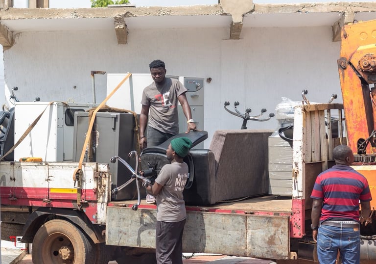 Three professional movers from TE Transporter Express load household appliances and furniture—includ