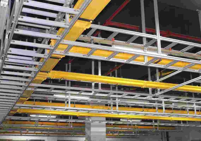 a large aluminum cable ladder with yellow cable tray and red pipes
