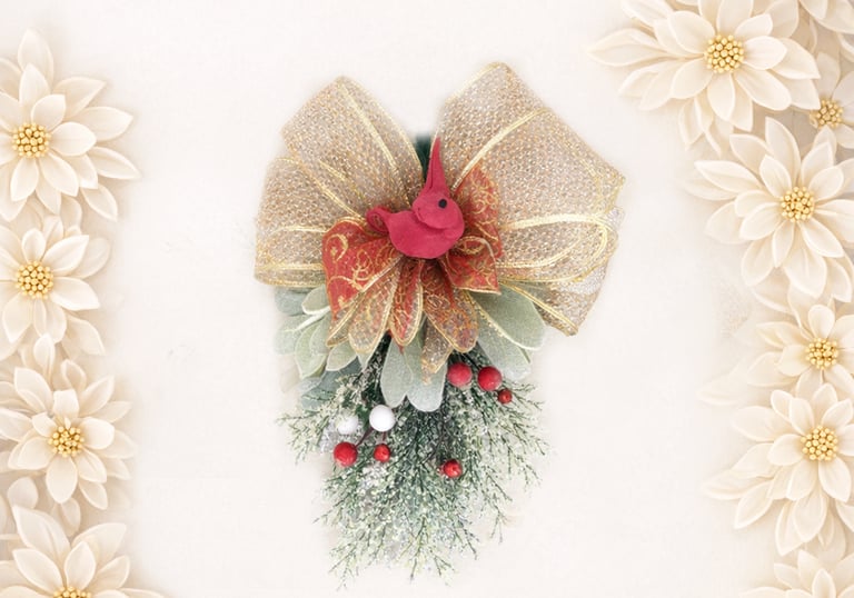 Festive Christmas swag decoration with a red bird, gold ribbon bow, and berries framed by white flowers.