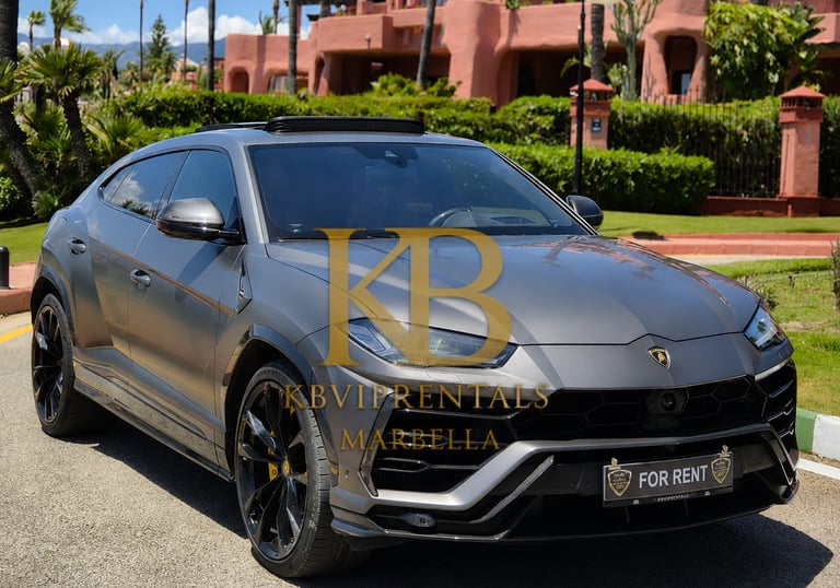 A matte grey Lamborghini Urus luxury SUV rental parked in front of a villa in Marbella.