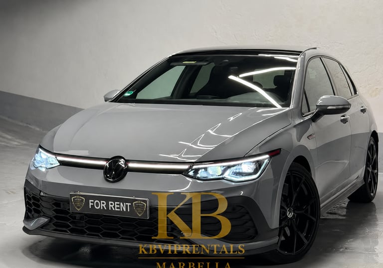 Grey Volkswagen Golf GTI rental car with black wheels parked in a Marbella showroom.
