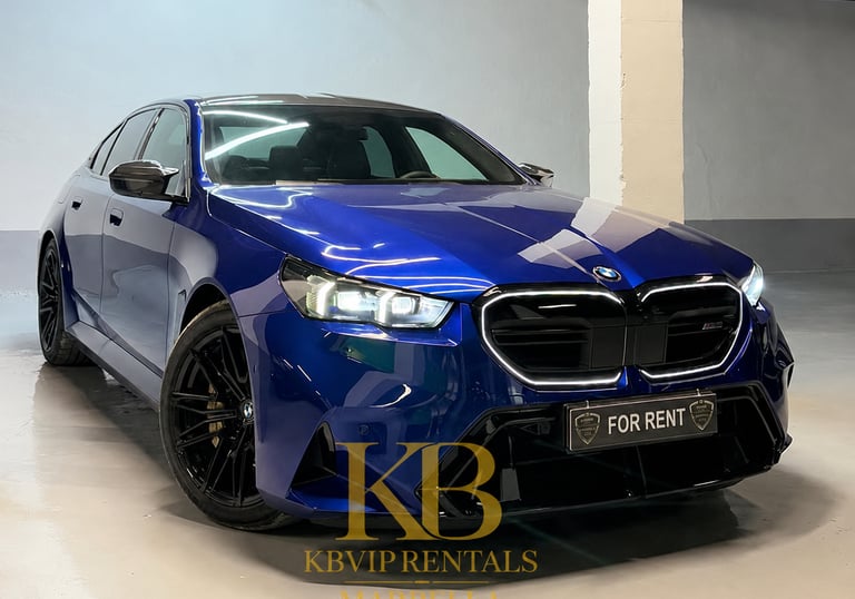 Luxury blue BMW M5 sedan for rent in Marbella featuring black rims and sleek design.