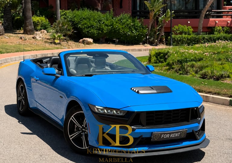 Blue Ford Mustang convertible sports car for rent on a sunny road in Marbella.