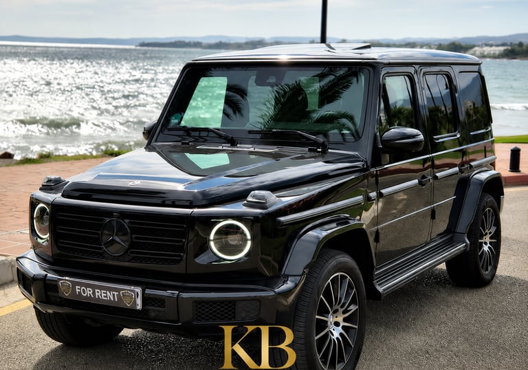 Black Mercedes G-Wagon luxury car rental parked by the sea in Marbella, Spain.