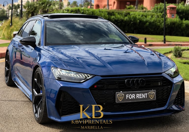 Luxury blue Audi RS6 Avant rental car parked on a sunny street in Marbella.