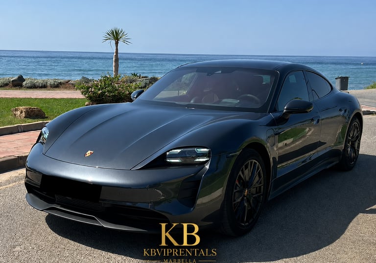 Luxury grey Porsche Taycan electric car parked by the Mediterranean Sea in Marbella.