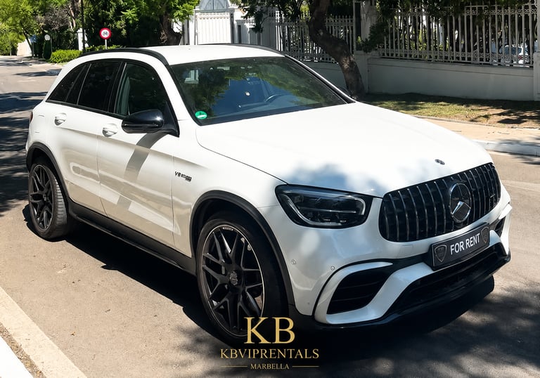 White Mercedes-Benz AMG luxury SUV for rent parked on a sunny street in Marbella.