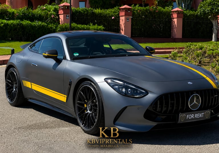 Matte grey Mercedes-AMG GT luxury sports car with yellow racing stripes parked outdoors for rent.